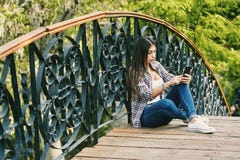 Young woman resting sitting on a wooden bridge stock image Young woman resting sitting on a wooden bridge stock image