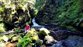 Young woman resting by a waterfall