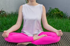A young woman sits in a lotus position, practices yoga on a yoga mat on the grass. Close-up, body parts. royalty free stock photos A young woman sits in a lotus position, practices yoga on a yoga mat on the grass. Close-up, body parts. royalty free stock photos