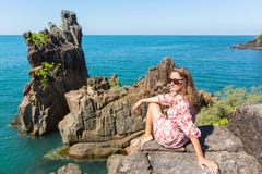 Young woman sitting on coastal rocks of Koh Chang. Island in Thailand Stock Photos Young woman sitting on coastal rocks of Koh Chang. Island in Thailand Stock Photos