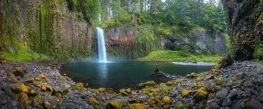 Young woman sitting on the rock at Beautiful waterfall of Abiqua Creek, Abiqua Falls, Oregon, USA. royalty free stock photos Young woman sitting on the rock at Beautiful waterfall of Abiqua Creek, Abiqua Falls, Oregon, USA. royalty free stock photos