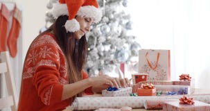 Young woman sitting wrapping Christmas gifts Royalty Free Stock Images Young woman sitting wrapping Christmas gifts Royalty Free Stock Images