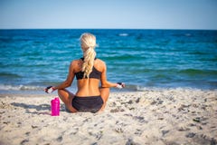 Young woman sitting in yoga pose at the beach royalty free stock image Young woman sitting in yoga pose at the beach royalty free stock image