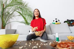Young woman sport fan watching match in a red t-shirt excited stock photography Young woman sport fan watching match in a red t-shirt excited stock photography