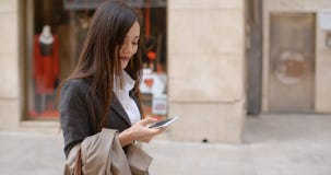 Young woman standing checking her mobile Royalty Free Stock Image Young woman standing checking her mobile Royalty Free Stock Image