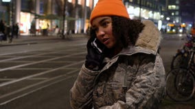 Young woman teenager talking on cell phone at night with trams by Alexanderplatz Station, Berlin, Germany stock footage Young woman teenager talking on cell phone at night with trams by Alexanderplatz Station, Berlin, Germany stock footage