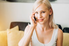 Young woman using phone while relaxing on sofa stock photography Young woman using phone while relaxing on sofa stock photography