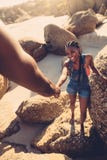 Man helping woman climbing rock at the beach Stock Photos Man helping woman climbing rock at the beach Stock Photos