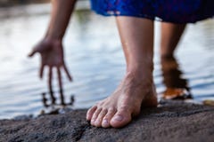 Young woman walks out of the water while touching the water with her hand stock image Young woman walks out of the water while touching the water with her hand stock image