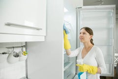 Young woman wearing rubber gloves cleaning the fridge Royalty Free Stock Images Young woman wearing rubber gloves cleaning the fridge Royalty Free Stock Images