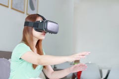 Young woman wearing virtual reality glasses at home. Royalty Free Stock Photography Young woman wearing virtual reality glasses at home. Royalty Free Stock Photography