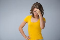 Young woman wearing yellow shirt and jeans shorts over grey bac. Image of young woman wearing yellow shirt and jeans shorts make faces over grey background Stock Images Young woman wearing yellow shirt and jeans shorts over grey bac. Image of young woman wearing yellow shirt and jeans shorts make faces over grey background Stock Images