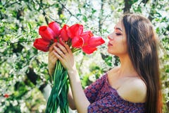 Young Woman With Tulips In A Blossoming Garden Stock Photo