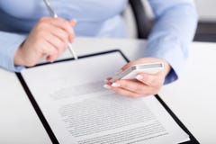 Young woman working with a mobile phone and holding a pen stock image Young woman working with a mobile phone and holding a pen stock image
