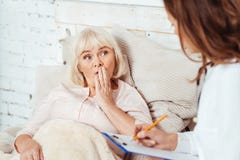 Yrkesmässig doktor som undersöker den äldre kvinnan arkivbild Yrkesmässig doktor som undersöker den äldre kvinnan arkivbild