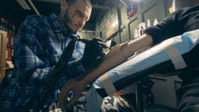 Yrkesmässig tattooerteckning på en handprotes, handikappad person stock video Yrkesmässig tattooerteckning på en handprotes, handikappad person stock video