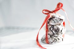 Yummy печенья crinkle шоколада с красной лентой на белой печь бумаге, концом вверх, макрос стоковое изображение rf Yummy печенья crinkle шоколада с красной лентой на белой печь бумаге, концом вверх, макрос стоковое изображение rf