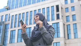 Z podnieceniem Muzułmańska dziewczyna czyta wiadomość na telefonie o pracy zatrudnia lub wchodzić do szkole wyższej zbiory wideo Z podnieceniem Muzułmańska dziewczyna czyta wiadomość na telefonie o pracy zatrudnia lub wchodzić do szkole wyższej zbiory wideo