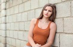 zadumany girle patrzeje ciebie na cementowym kolor cegieł tle z przykrością fotografia stock zadumany girle patrzeje ciebie na cementowym kolor cegieł tle z przykrością fotografia stock