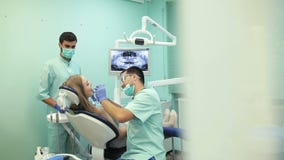 Zahnarzt, der zahnmedizinische kurierende UVlampe auf Zähnen des Patienten verwendet stock video Zahnarzt, der zahnmedizinische kurierende UVlampe auf Zähnen des Patienten verwendet stock video
