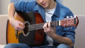 Zainteresowany nastolatek bawić się gitarę akustyczną, amatorski muzykalny hobby, czas wolny zbiory wideo Zainteresowany nastolatek bawić się gitarę akustyczną, amatorski muzykalny hobby, czas wolny zbiory wideo