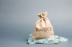 Zak met geld en meetlint en de woordbegroting Beperkte begroting Gebrek aan geld Het concept het accumuleren van geld in stock afbeelding Zak met geld en meetlint en de woordbegroting Beperkte begroting Gebrek aan geld Het concept het accumuleren van geld in stock afbeelding