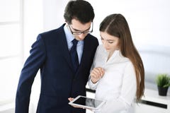 Zakenlieden en vrouw die tabletcomputer in modern bureau met behulp van Collega's of bedrijfmanagers op het werk partners royalty-vrije stock fotografie Zakenlieden en vrouw die tabletcomputer in modern bureau met behulp van Collega's of bedrijfmanagers op het werk partners royalty-vrije stock fotografie