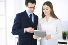 Zakenlieden en vrouw die tabletcomputer in modern bureau met behulp van Collega's of bedrijfmanagers op het werk partners stock afbeelding Zakenlieden en vrouw die tabletcomputer in modern bureau met behulp van Collega's of bedrijfmanagers op het werk partners stock afbeelding