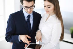 Zakenlieden en vrouw die tabletcomputer in modern bureau met behulp van Collega's of bedrijfmanagers op het werk partners stock afbeelding Zakenlieden en vrouw die tabletcomputer in modern bureau met behulp van Collega's of bedrijfmanagers op het werk partners stock afbeelding
