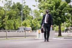 Zakenman lopen openlucht met aktentas die een gasmasker dragen royalty-vrije stock afbeelding Zakenman lopen openlucht met aktentas die een gasmasker dragen royalty-vrije stock afbeelding