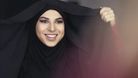 Zakończenie portret muzułmańska kobieta w obywatelu odziewa przystosowywać jej hijab i ono uśmiecha się podczas gdy patrzejący w zdjęcie wideo Zakończenie portret muzułmańska kobieta w obywatelu odziewa przystosowywać jej hijab i ono uśmiecha się podczas gdy patrzejący w zdjęcie wideo
