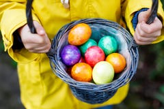 Zakończenie ręki małe dziecko z kolorowymi Wielkanocnymi jajkami w koszu fotografia stock Zakończenie ręki małe dziecko z kolorowymi Wielkanocnymi jajkami w koszu fotografia stock