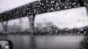 Zakończenie up strzelał raindrop na samochodowym nadokiennym szkle i rozmytego ruch drogowego na nastroju dżdżystym chmurzącym ci zbiory Zakończenie up strzelał raindrop na samochodowym nadokiennym szkle i rozmytego ruch drogowego na nastroju dżdżystym chmurzącym ci zbiory