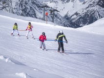 Zams, Austria - 22 Februar 2015: Ski resort. Children with instructor skiing and practicing the correct moves on slope in Alps. royalty free stock photos Zams, Austria - 22 Februar 2015: Ski resort. Children with instructor skiing and practicing the correct moves on slope in Alps. royalty free stock photos