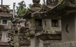 Zamyka do wiele różnych Kamiennych lampionów na sposobie w Japonia buddyjska świątynia Higo Honmyo świątynia, Kumamoto prefektura zdjęcie royalty free Zamyka do wiele różnych Kamiennych lampionów na sposobie w Japonia buddyjska świątynia Higo Honmyo świątynia, Kumamoto prefektura zdjęcie royalty free