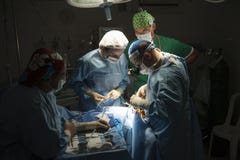 Zaopatrzenie medyczne wykonuje chirurgicznie operację w jaskrawej nowożytnej sala operacyjnej obraz stock Zaopatrzenie medyczne wykonuje chirurgicznie operację w jaskrawej nowożytnej sala operacyjnej obraz stock