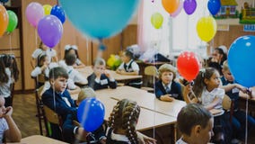 Zaporozhye, Ucrânia - 1º de setembro de 2018: Fundo borrado das crianças na farda da escola que senta-se na sala de formação deco fotografia de stock royalty free Zaporozhye, Ucrânia - 1º de setembro de 2018: Fundo borrado das crianças na farda da escola que senta-se na sala de formação deco fotografia de stock royalty free