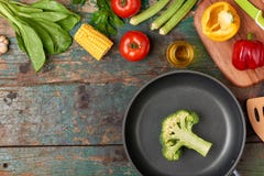 Zawiera świeżych organicznie warzywa i frypan na drewnianej podłoga Zdjęcie Stock Zawiera świeżych organicznie warzywa i frypan na drewnianej podłoga Zdjęcie Stock
