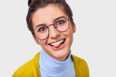 Zbliżenie pracowniany portret optymistycznie śmieszna kobieta z babeczki fryzurą pokazuje jej jęzor i jest ubranym wokoło modnych zdjęcie stock Zbliżenie pracowniany portret optymistycznie śmieszna kobieta z babeczki fryzurą pokazuje jej jęzor i jest ubranym wokoło modnych zdjęcie stock