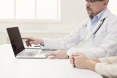 Zbliżenie doktorski i cierpliwy obsiadanie przy biurkiem zdjęcia stock Zbliżenie doktorski i cierpliwy obsiadanie przy biurkiem zdjęcia stock