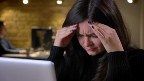 Zbliżenie dorosłej brunetki caucasian bizneswoman pracuje na laptopie i dostaje migrenę męcząca zbiory wideo Zbliżenie dorosłej brunetki caucasian bizneswoman pracuje na laptopie i dostaje migrenę męcząca zbiory wideo