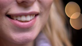 Zbliżenie krótkopęd ono uśmiecha się seductively z bokeh dorosłej atrakcyjnej blondynki caucasian żeńskie wargi zaświeca na tle zbiory Zbliżenie krótkopęd ono uśmiecha się seductively z bokeh dorosłej atrakcyjnej blondynki caucasian żeńskie wargi zaświeca na tle zbiory