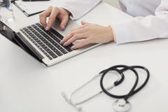Zbliżenie lekarek ręki na laptop klawiaturze obrazy stock Zbliżenie lekarek ręki na laptop klawiaturze obrazy stock