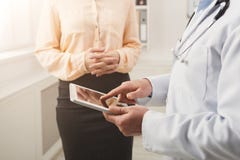 Zbliżenie lekarka wskazuje w pastylkę i pacjenta obrazy stock Zbliżenie lekarka wskazuje w pastylkę i pacjenta obrazy stock
