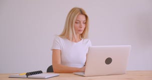 Zbliżenie portret dorosły caucasian blondynka bizneswoman używa laptop patrzeje kamerę ono uśmiecha się radośnie indoors zbiory Zbliżenie portret dorosły caucasian blondynka bizneswoman używa laptop patrzeje kamerę ono uśmiecha się radośnie indoors zbiory
