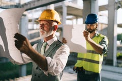 Zeker team van architecten en ingenieurs die aan bouwwerf samenwerken stock fotografie Zeker team van architecten en ingenieurs die aan bouwwerf samenwerken stock fotografie