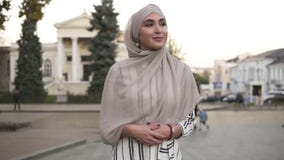 Zekere en aantrekkelijke vrouw die een hijab dragen Jonge vrouw die door de stadsstraat lopen met mooie oude stijl stock footage Zekere en aantrekkelijke vrouw die een hijab dragen Jonge vrouw die door de stadsstraat lopen met mooie oude stijl stock footage