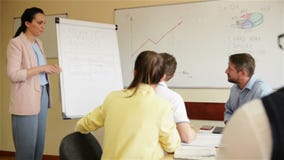 Zekere onderneemster die tekeningspresentatie op flipchart geven aan collega's in bestuurskamer Het uitvoerende manager tonen stock video Zekere onderneemster die tekeningspresentatie op flipchart geven aan collega's in bestuurskamer Het uitvoerende manager tonen stock video