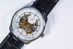 Zelenodolsk, Ukraine, on January 5, 2019. The men`s watch with a leather black thong and gold gears and the white dial lies. stock photography Zelenodolsk, Ukraine, on January 5, 2019. The men`s watch with a leather black thong and gold gears and the white dial lies. stock photography