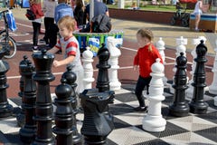 Zelenogradsk, Rússia As crianças jogam peças do jogo de xadrez da rua Região de Kaliningrad imagem de stock Zelenogradsk, Rússia As crianças jogam peças do jogo de xadrez da rua Região de Kaliningrad imagem de stock